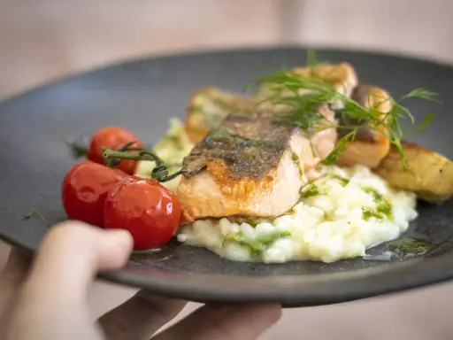 En läcker laxfilé med krämig risotto, körsbärstomater och dill. En perfekt rätt att njuta av, som en del av en **white guide Dalarna**-upplevelse.