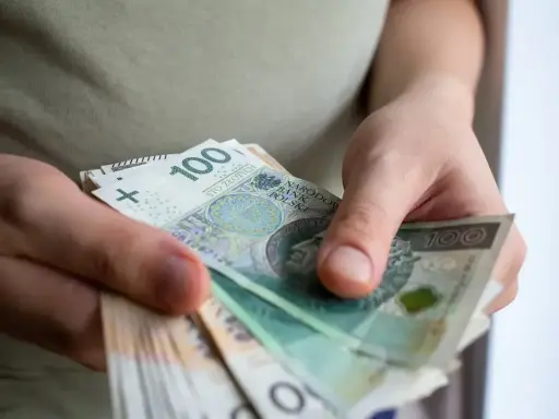 Dłonie liczą banknoty 100 zł. To może być pomoc de minimis dla przedsiębiorcy.