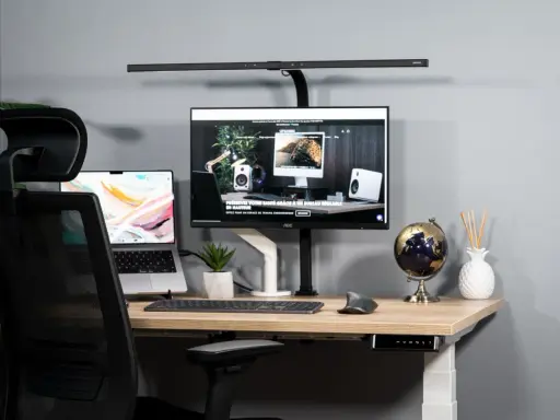 Bureau moderne avec un écran ergonomique, un ordinateur portable et une chaise de bureau.
