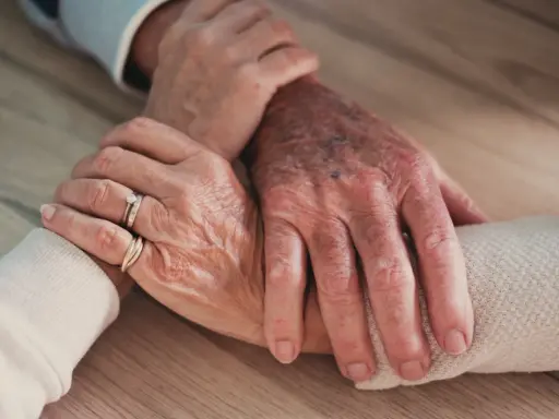 Mains âgées se tenant, symbolisant le soutien et l'amour, même face à un conjoint narcissique.