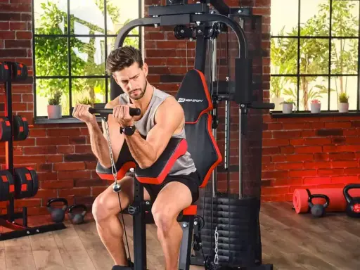 Mężczyzna ćwiczy biceps na domowej siłowni. Sprzęt i akcesoria, jak hantle i kettlebelle, to dowód na to, że polskie marki sportowe oferują wszystko, co potrzebne do treningu.