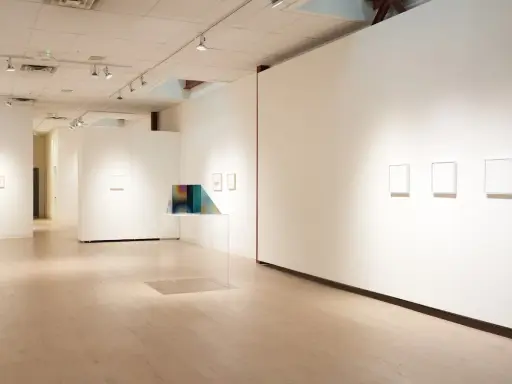 Inside the Richard Levy Gallery, minimalist artworks are displayed on white walls with polished wooden floors.