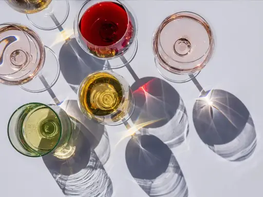 Fünf Gläser Wein in verschiedenen Farben, darunter Rot, Rosé und Weiß. Die Frage: ist alkoholfreier Wein wirklich alkoholfrei?