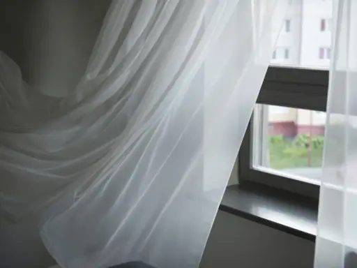 Delikatne, białe firanki falujące przy oknie. Zastanawiasz się, jak wybielić firanki, by znów lśniły czystością?