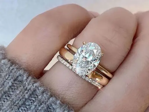 Un solitario anello con diamante ovale, simbolo di un amore eterno e prezioso, adorna un dito.