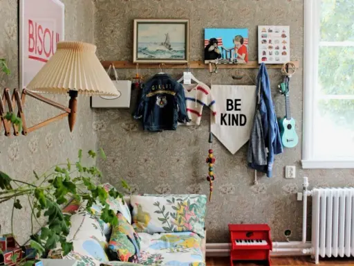 En mysig vrå med barnkläder, en gitarr och en "Be Kind"-flagga, inspirerad av Johanna Bradford blogg.