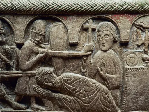 Detaljerad stenrelief från medeltiden konst visar en dramatisk scen med soldater och en liggande figur. En man håller ett kors.