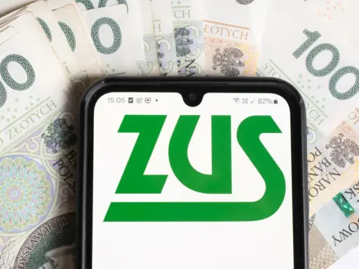 Dodatek pielęgnacyjny z ZUS: sprawdź, komu przysługuje. Na ekranie telefonu logo ZUS, w tle banknoty 100 zł.