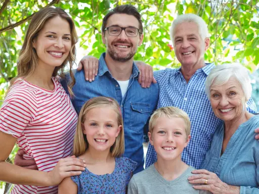 Familia sonriente, de abuelos a nietos, mostrando el factor hereditario en sus rasgos.