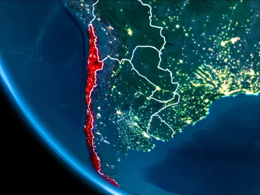 Widok z kosmosu nocą, gdzie leży Chile, podkreślone na czerwono, wzdłuż wybrzeża Pacyfiku.
