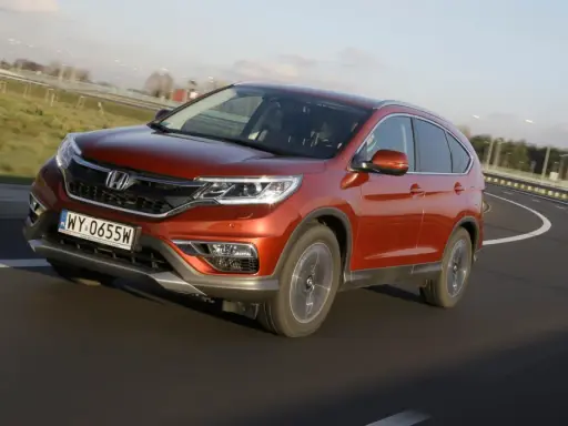 Pomarańczowy Honda CR-V 1.6 diesel na zakręcie drogi. Czy to początek honda cr-v 1.6 diesel usterki?