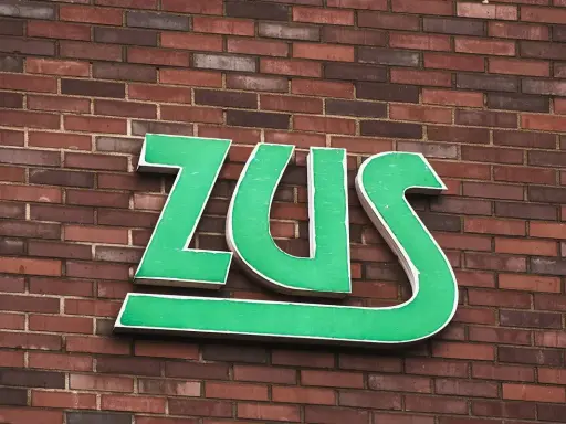 Zielone litery ZUS na ceglanej ścianie. Zastanawiasz się, subkonto co to? To miejsce, gdzie gromadzone są Twoje środki.