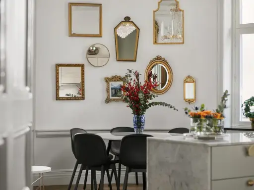 En samling antika speglar ramar in matbordet och skapar en elegant atmosfär.