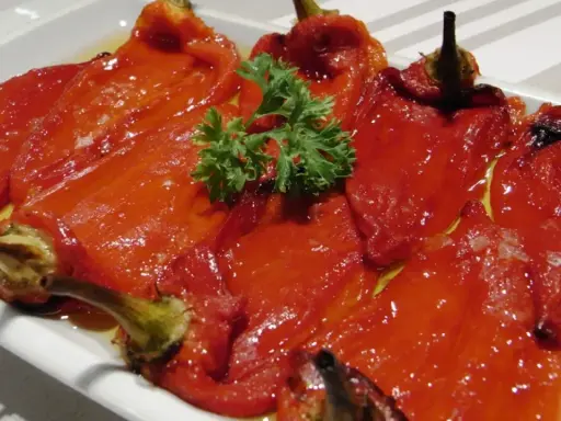 Pimientos asados en freidora de aire, tiernos y jugosos, servidos en una bandeja con perejil fresco.
