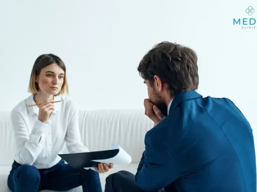 Kobieta z notatkami i mężczyzna w garniturze rozmawiają. Tak wygląda psychoterapia: wsparcie i zrozumienie w trudnych chwilach.