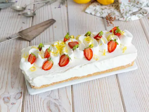 Cheesecake citron facile rapide, garni de fraises fraîches et de zestes de citron. Un délice crémeux et acidulé.