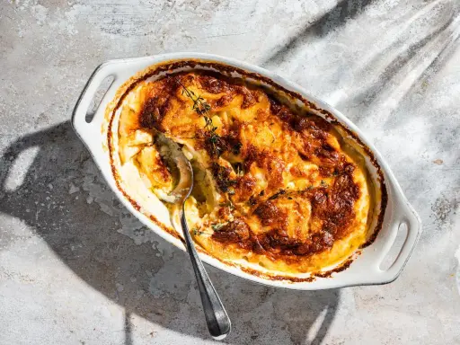 Ein goldbraun gebackener Gratin Dauphinois im ovalen Auflauf, bereit zum Servieren. Dieses Gratin Dauphinois Rezept ist ein Klassiker.