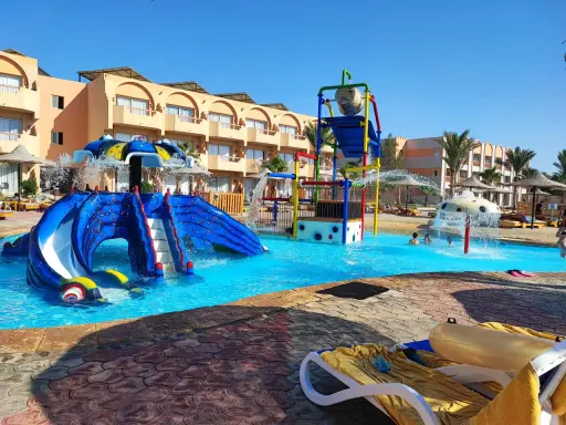 Divertimento acquatico a Marsa Alam con bambini: scivoli blu, giochi d'acqua e piscine cristalline in un resort soleggiato.