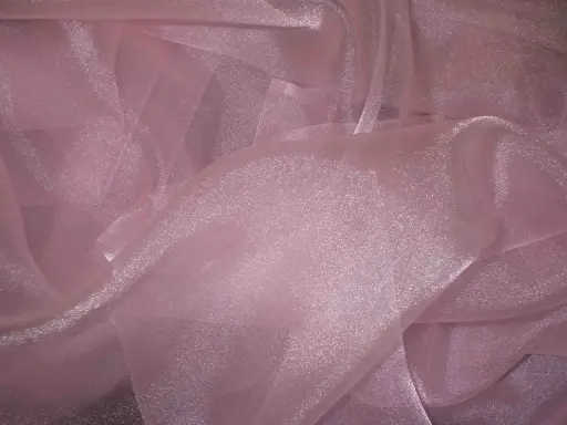 A shimmering pink organza fabric, with its sheer, crisp texture, drapes elegantly, catching the light.