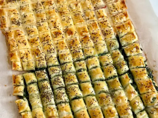 Torta salata con pasta sfoglia, ripiena di spinaci e cosparsa di semi di chia. Un'idea gustosa su cosa mettere dentro la pasta sfoglia.