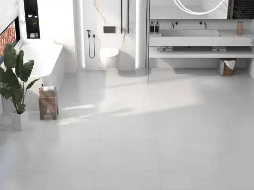 Salle de bain moderne avec baignoire, douche, lavabo et toilettes, le tout sur un sol en dalle pvc ou carrelage blanc.