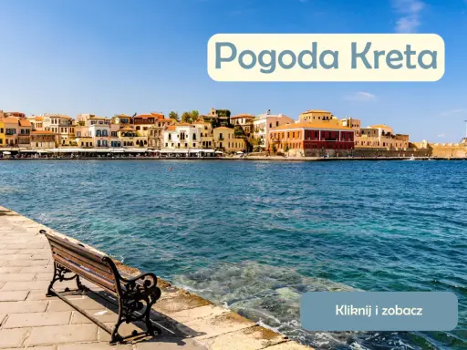 Słoneczna pogoda na Krecie w lipcu. Widok na port z kolorowymi kamienicami i ławką nad turkusową wodą.