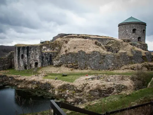 Bohus fästning reser sig stolt mot en molnig himmel, dess stenmurar vittnar om århundraden av historia.