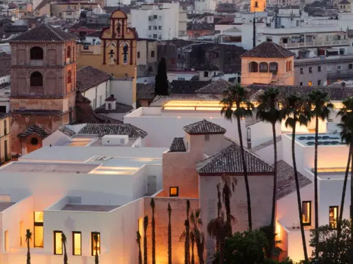 Das Picasso Museum in Spanien, Malaga, mit seinen modernen weißen Gebäuden und Palmen im Abendlicht.