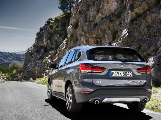 Szary BMW X1 na krętej drodze wśród skał. Sprawdź aktualną bmw x1 cena i wybierz się na przygodę!