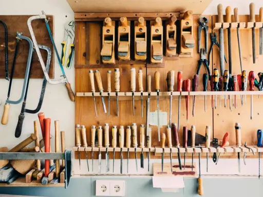 Un taller organizado con sierras, cepillos, destornilladores y limas colgados en la pared. Un ejemplo de **ordenar herramientas casero** para tener todo a mano.