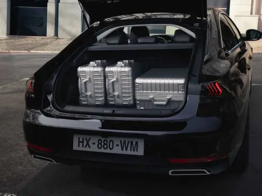 Maletero del Peugeot 508 SW listo para un viaje, con tres maletas plateadas de gran capacidad.