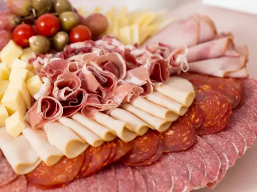 Tagliere ricco di salumi e formaggi, un assaggio di vera cucina emiliana. Prosciutto crudo, salame, mortadella, formaggio a cubetti, pomodorini e olive.