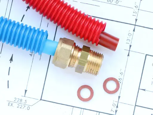Tuyaux din40 bleus et rouges, raccord laiton et rondelles sur un plan technique.