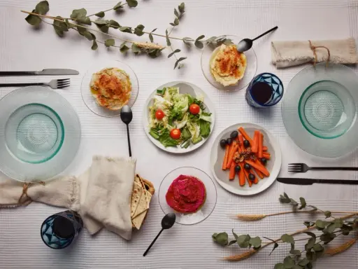Un repas végétarien servi à l'assiette : houmous, salade, carottes et betterave. Une belle définition du service à l'assiette.
