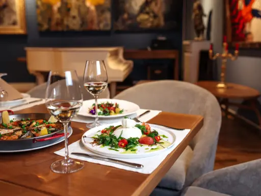 Un dîner romantique dans un restaurant sur Tours. Paella et burrata fraîchement préparées, accompagnées de vin blanc.