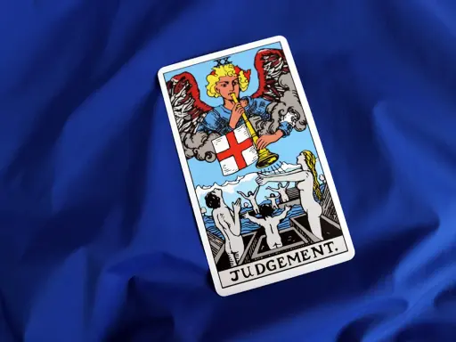 Karta Sąd Ostateczny Tarot. Anioł gra na trąbie, budząc ludzi z grobów.