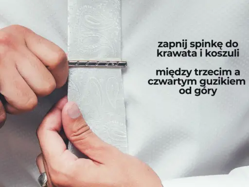 Mężczyzna zapina spinkę do krawata i koszuli między trzecim a czwartym guzikiem od góry. Elegancki sposób na noszenie spinki.