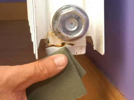 Lijando la zona oxidada de un radiador para prevenir una fuga.