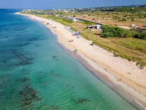 Spiaggia di Torre Vado, Pescoluse, con acque cristalline e sabbia dorata. Un luogo ideale per rilassarsi e godersi il sole.
