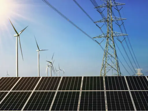 Solarpanels und Windräder, Teil von regenerativen Kraftwerken, unter blauem Himmel mit Strommasten.