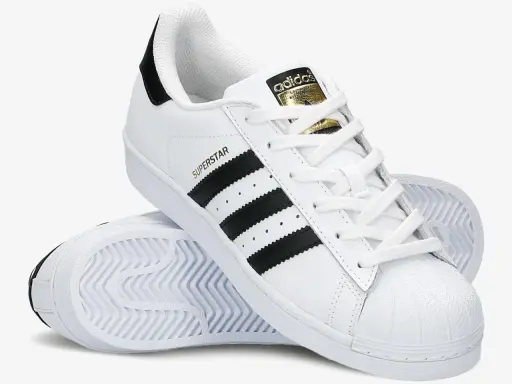 Białe adidas Superstar z czarnymi paskami i złotym logo. Poznaj, czym się różnią modele.