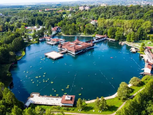 Termalne jezioro z pływającymi budynkami i ludźmi kąpiącymi się w wodzie. To jedno z najpiękniejszych miejsc nad Balatonem.