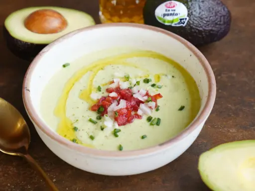 Un cremoso gazpacho de aguacate, coronado con tomate picado, cebolla y cebollino. Un chorrito de aceite de oliva realza su frescura.