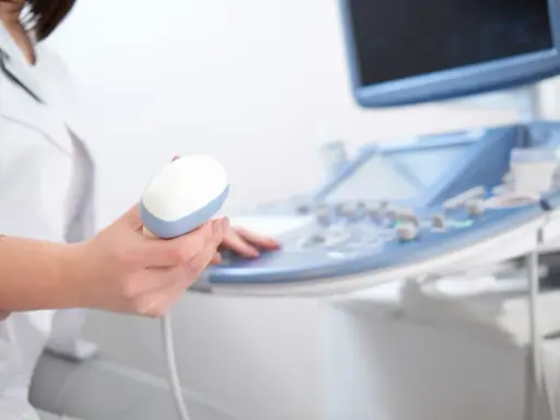 Lekarz trzyma sondę aparatu USG, przygotowując się do badania echo serca. Prawidłowe parametry echo serca są kluczowe dla diagnozy.
