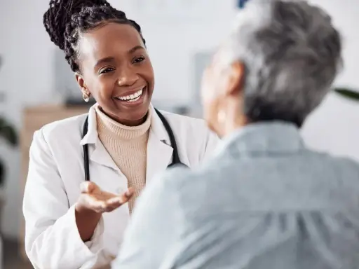 Doctora sonriente explica a paciente sobre síntomas de clamidia en mujeres, ofreciendo apoyo y claridad.