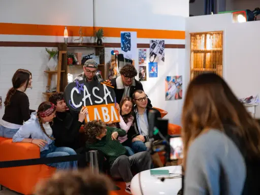 A group of young people pose for a photo, holding a sign that says "CASA LABA".