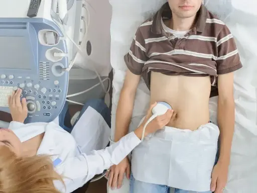 Lekarz wykonuje USG jamy brzusznej, aby przeprowadzić test na zapalenie wyrostka robaczkowego.