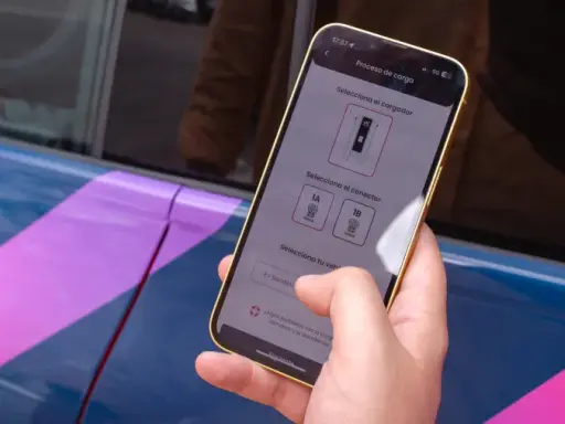 Mano usa el móvil para seleccionar el conector de carga en la mejor app cargadores eléctricos.