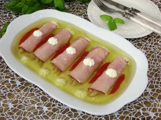 Roladki z szynki z papryką w galarecie, ozdobione kleksami majonezu. Elegancka przystawka na specjalne okazje.