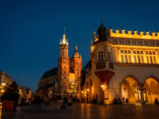 Wieczorny spacer po Rynku Głównym w Krakowie. Sukiennice i Kościół Mariacki oświetlone, tworzą magiczną atmosferę na udany weekend w Krakowie.